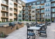 Thumbnail 7 of 53 - an outdoor patio with tables and chairs at the bradley braddock road station apartments